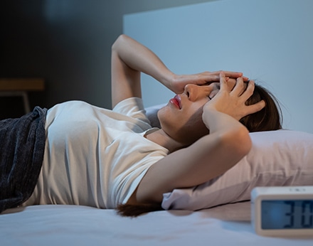 夜中に眠れず悩む女性、不眠の様子を表現